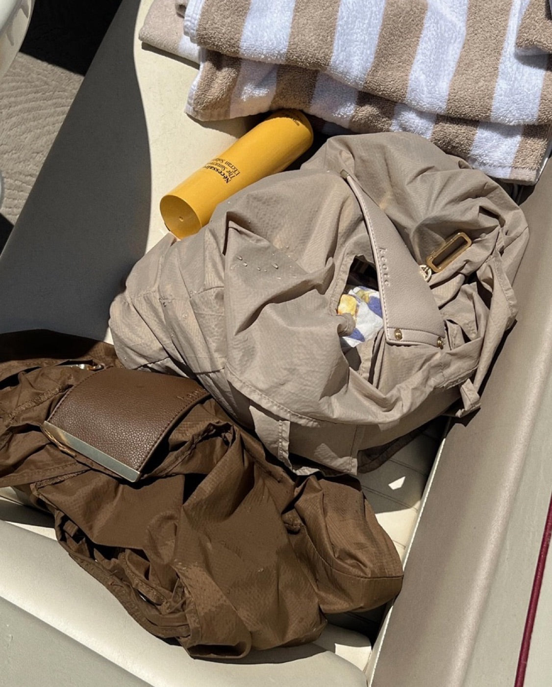 Lovelle Fold på båten med handdukar och solkräm